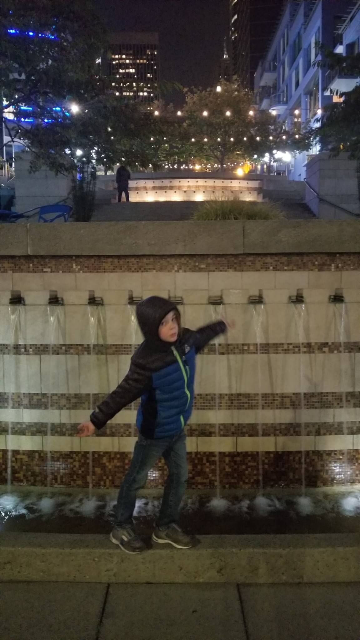 Child by a waterfall walkway at night in Seattle