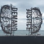 Two huge wire sculptures of half faced, half words, on the Chicago waterfront - they say Demand and Justice