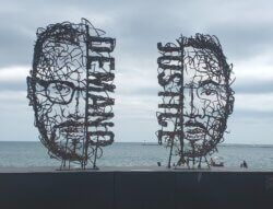Two huge wire sculptures of half faced, half words, on the Chicago waterfront - they say Demand and Justice